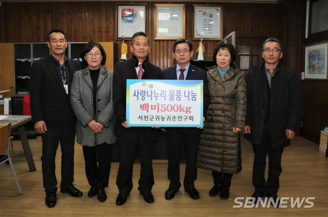 노희식 서천군귀농귀촌연구회장(왼쪽에서 세번째) 등이 전달식에 참여해 기념사진을 찍고있다