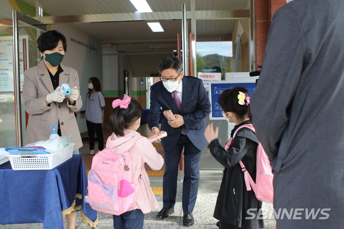 정태모 서천교육장이 등교하는 학생들에게 선물을 나줘주고 있다. (사진=서천교육지원청)