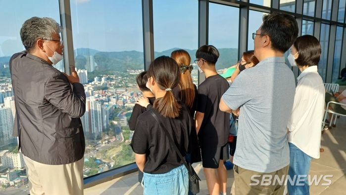 천안시태조산청소년수련관 하늘에서 듣는 천안학 강의에 참가한 가족들이 타운홀 전망대에서 설명을 듣고 있다.